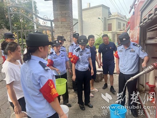 民輔警跟隨消防水車作業(yè)，通過肩挑手提的方式將清水送入行動(dòng)不便的老年、殘障村民的家中（通訊員 李麗君 攝） (3).jpg.jpg