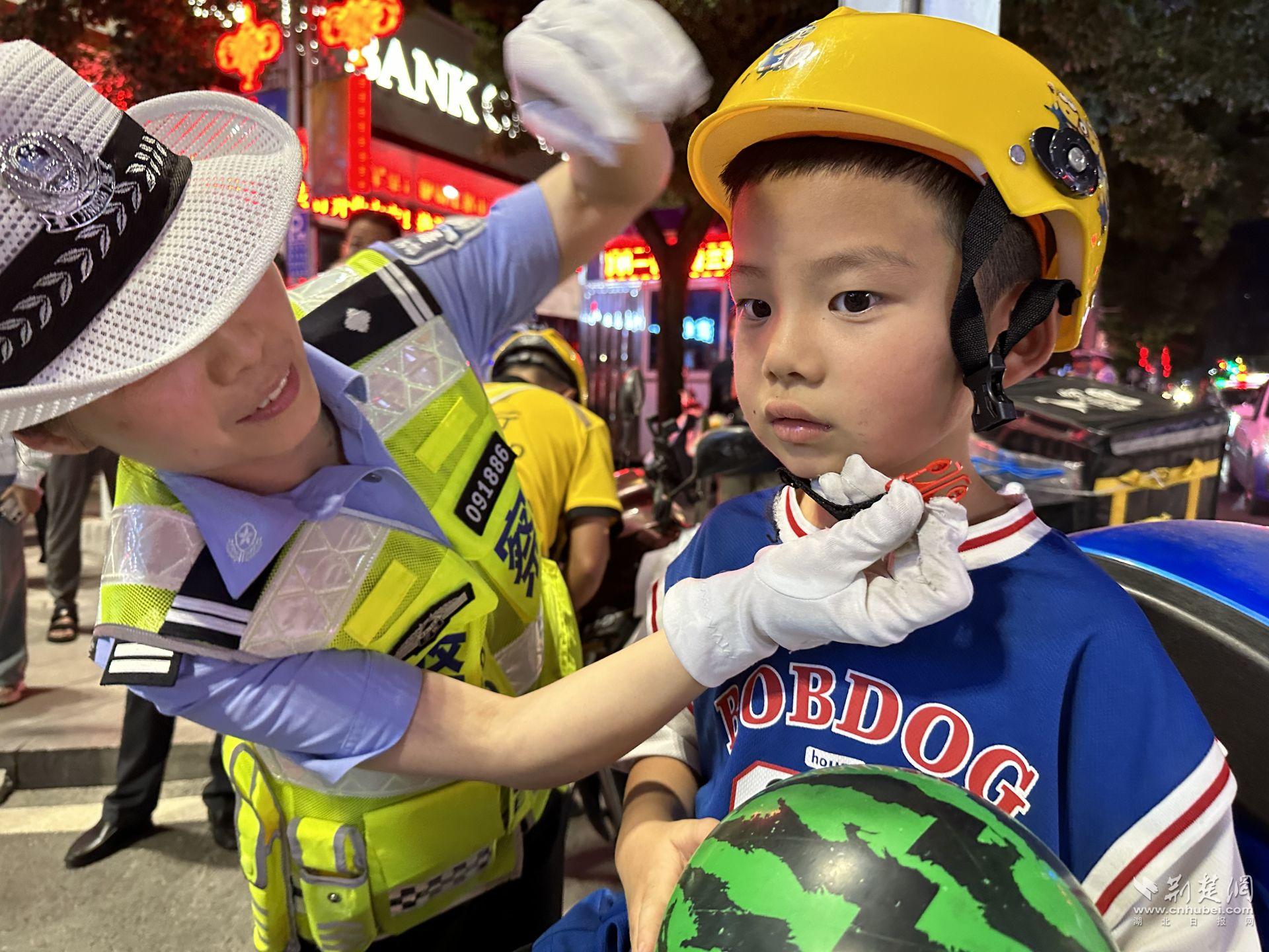 建始縣公安局交警為小朋友戴好頭盔.jpg.jpg