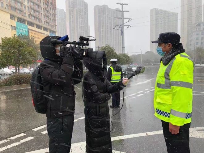 孝感市融媒體中心楊亞玲（風(fēng)雪中，采訪疫情期間重返一線的退休警察）_副本.jpg.jpg